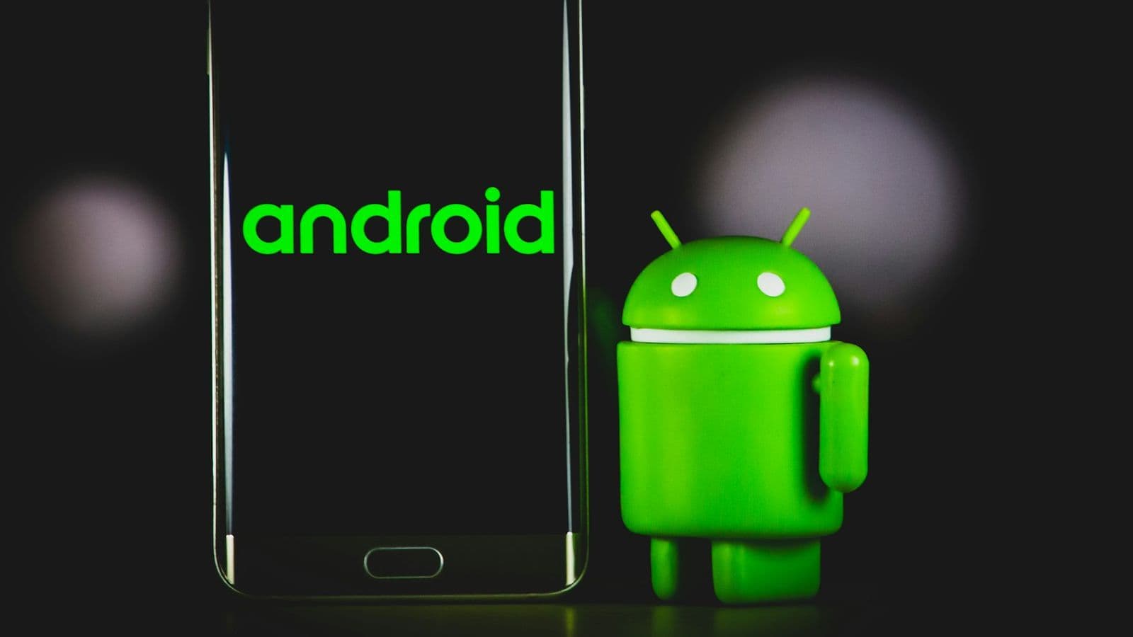 An Android phone beside the Android mascot figure.